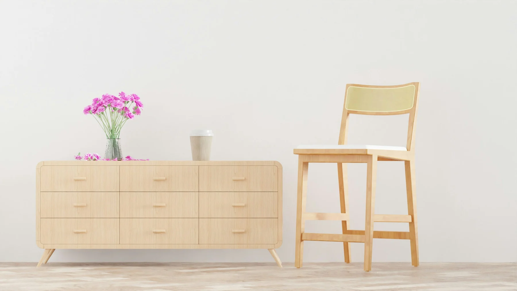 A light wooden dresser and a matching chair against a plain wall