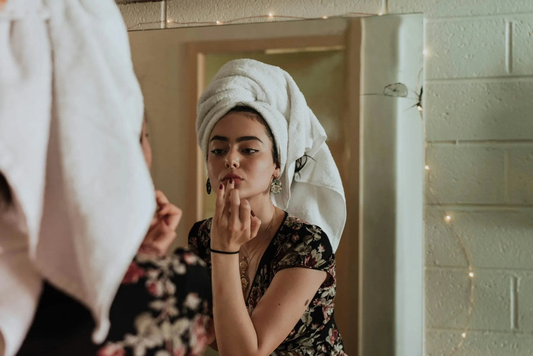 A woman getting ready in front of a mirror